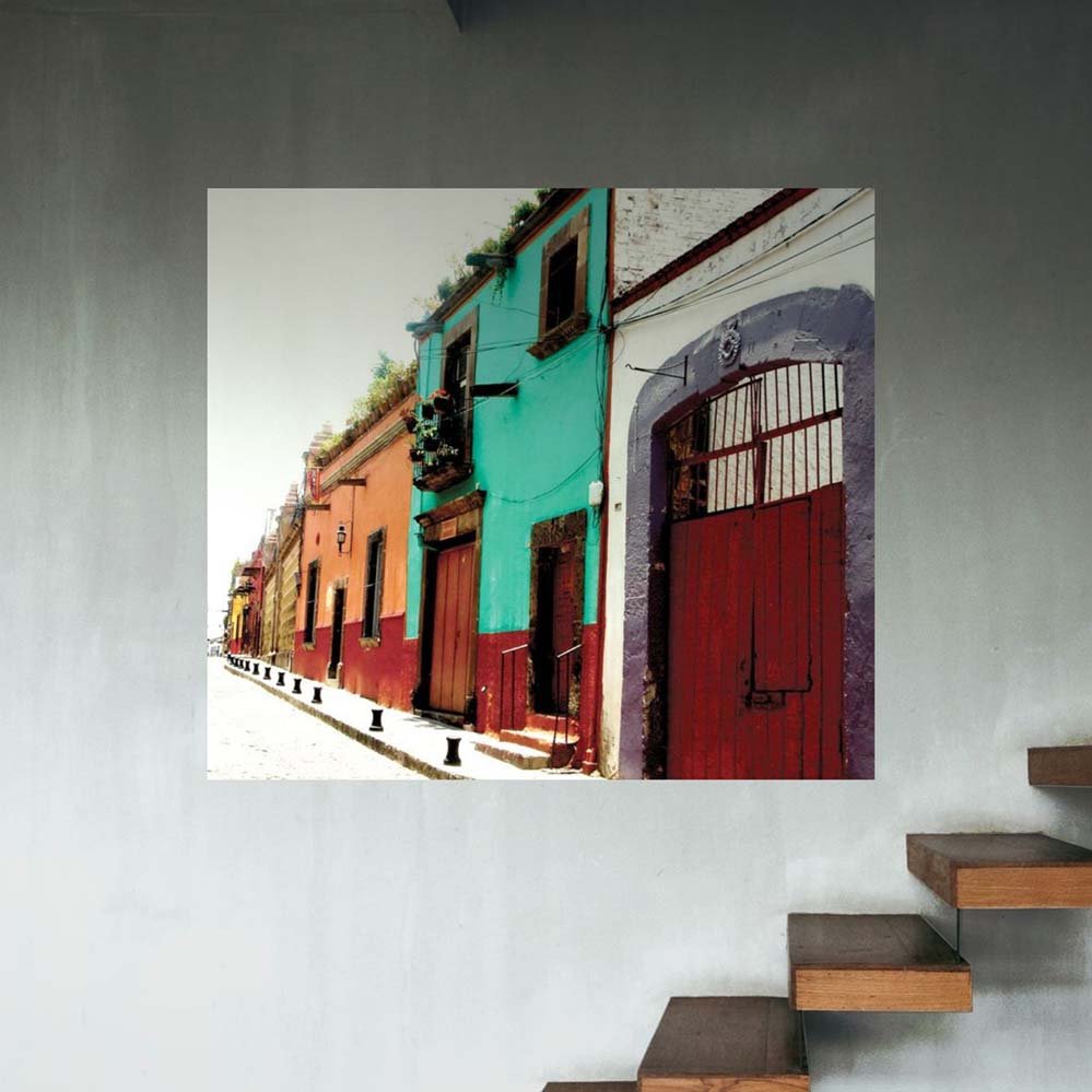 48 inch colorful Mexican street scene with buildings poster displayed on a wall with wooden steps in the foreground.