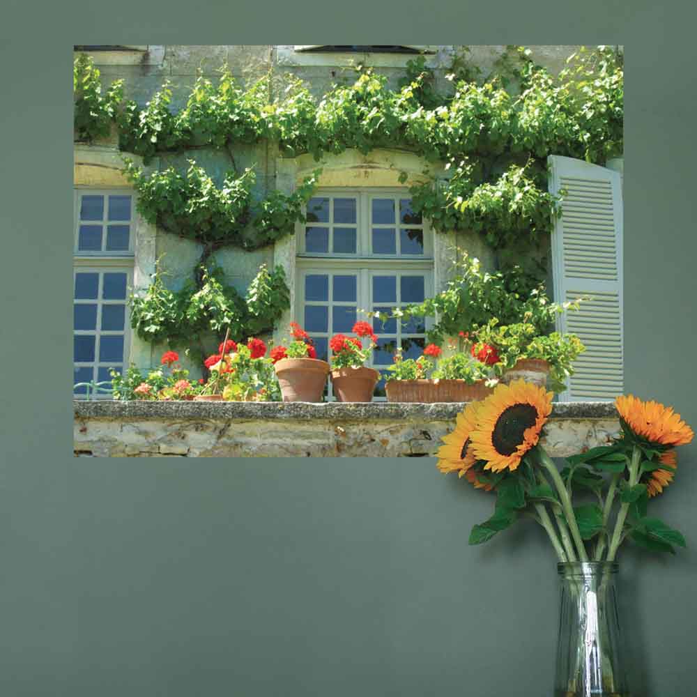 48 inch decal of a terrace in Auvillar France with ivy and flowerpots installed on a wall above a jar with sunflowers