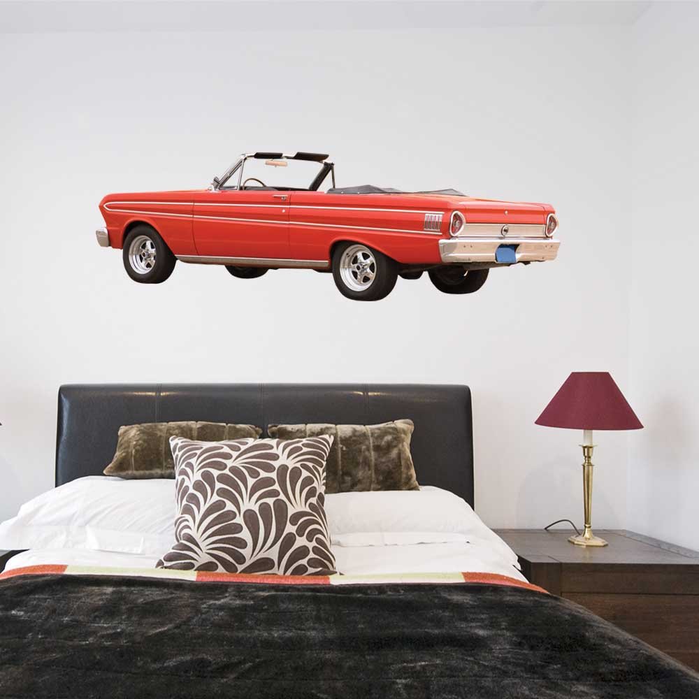 60 inch Red classic Ford Falcon car decal on a white wall above a bed with decorative pillows and a lamp.