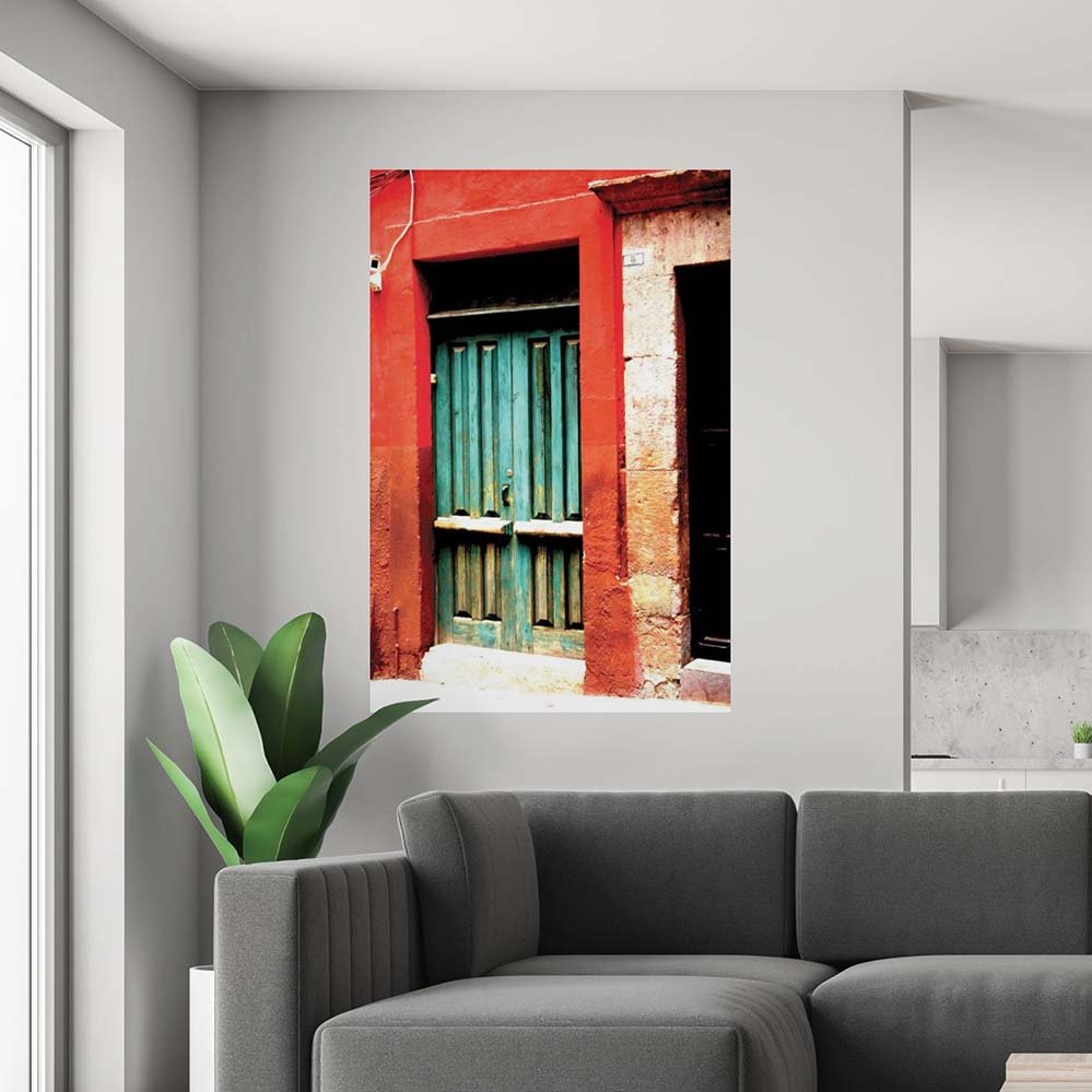 60 inch decal of a red frame with green door of a Mexican home installed on a wall above a sofa and plant