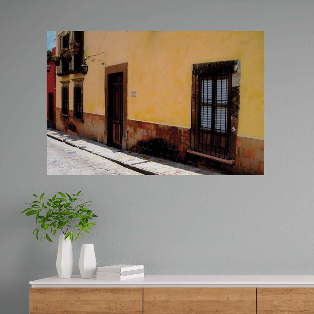 60 inch poster Mexican street and yellow house architecture displayed on wall above counter