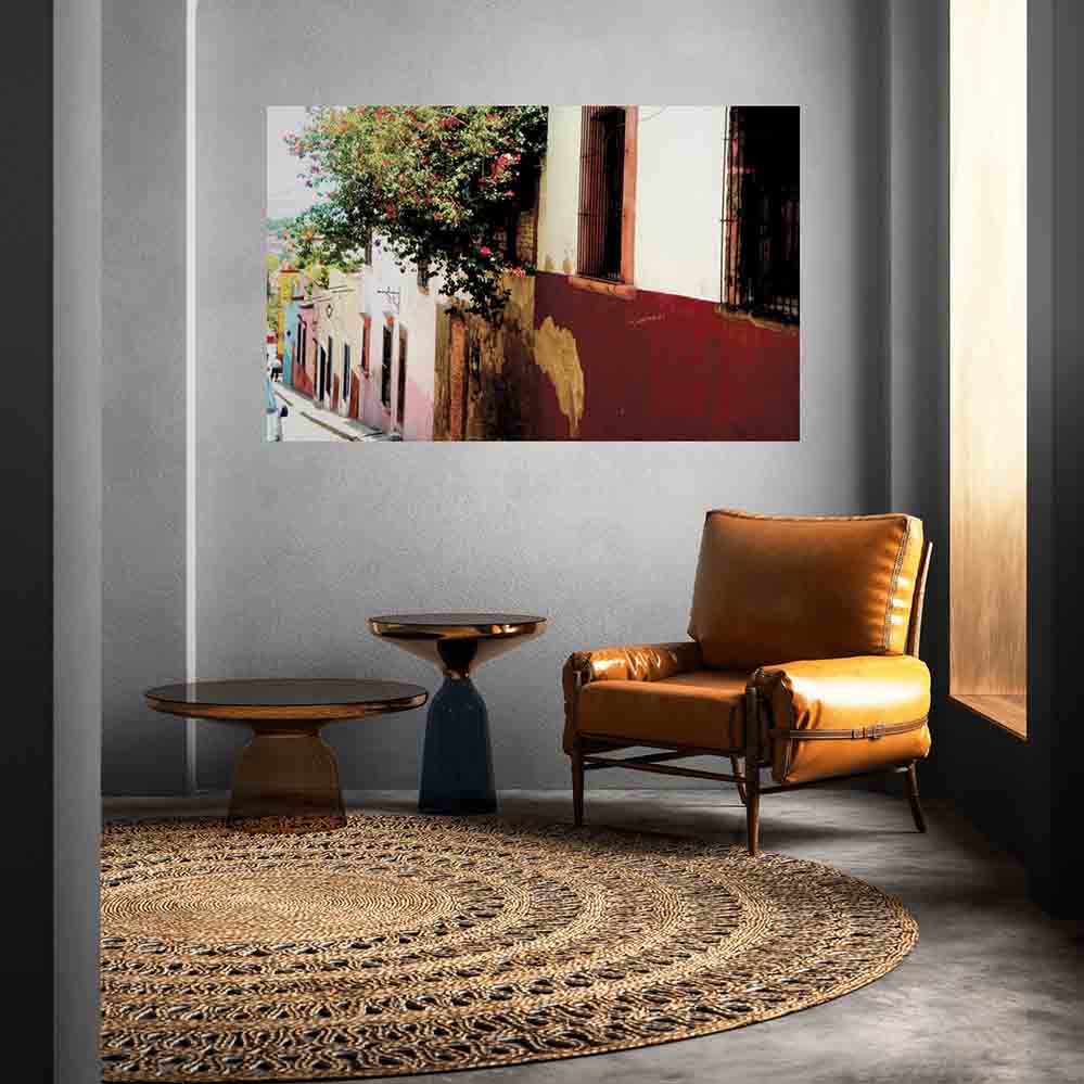 60 inch wall decal of Mexican street homes with floral bushes installed on a wall above leather chair and end table