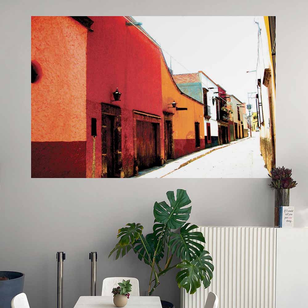 60 inch Colorful Mexican street scene poster with red and yellow buildings displayed on a wall above a dining area.