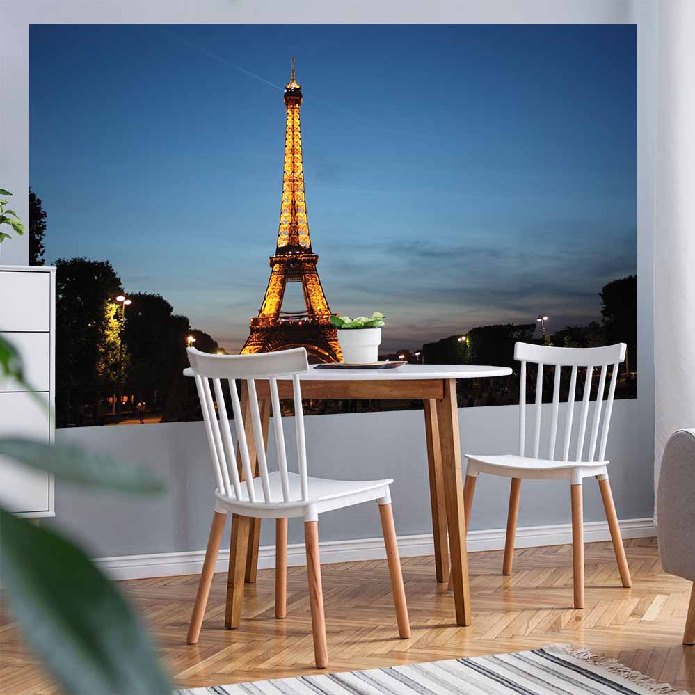 60 inch poster of the Eiffel Tower illuminated at dusk displayed on a wall with a small kitchen table and chars in foreground