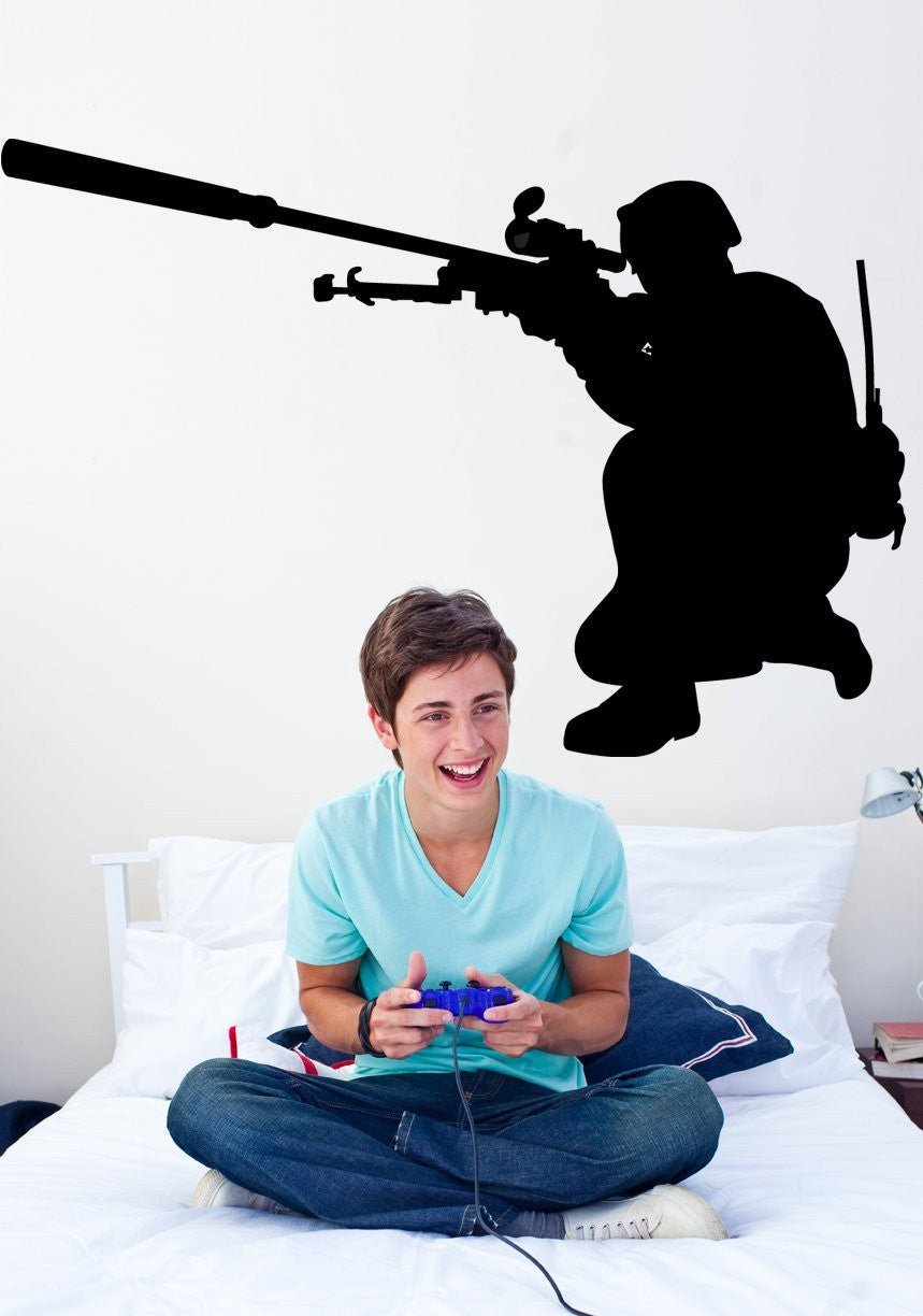 Military sniper kneeling with scoped rifle silhouette wall decal by Jaycee Haynes on wall in a teens bedroom