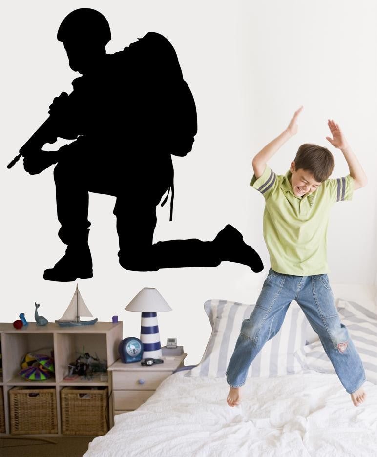 Military resting soldier kneeling with rifle and field pack silhouette wall decal by Jaycee Haynes installed on wall in young boys room