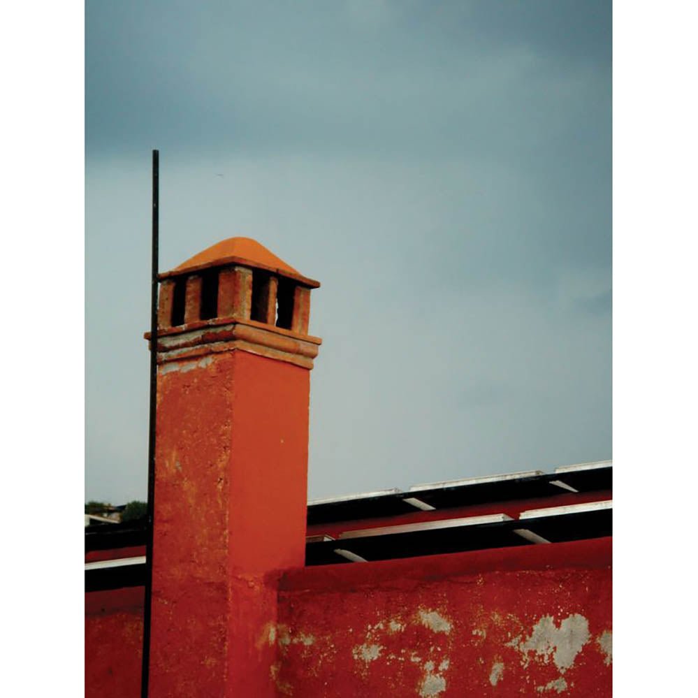 Red brick Mexican chimney on a building with a cloudy sky background printed | Wallhogs