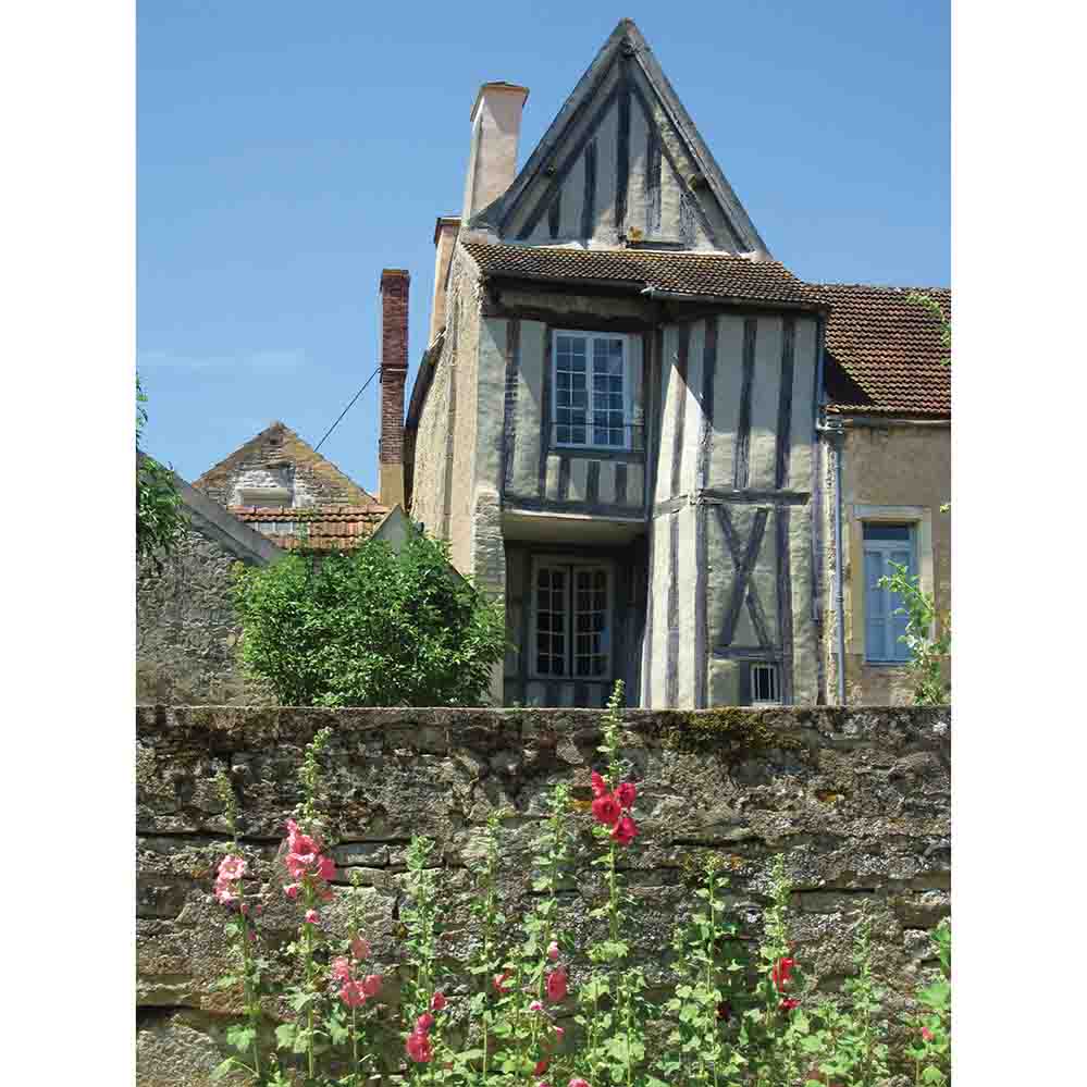 Traditional half-timbered house in Noyers France with flowers in the foreground gloss poster printed | Wallhogs