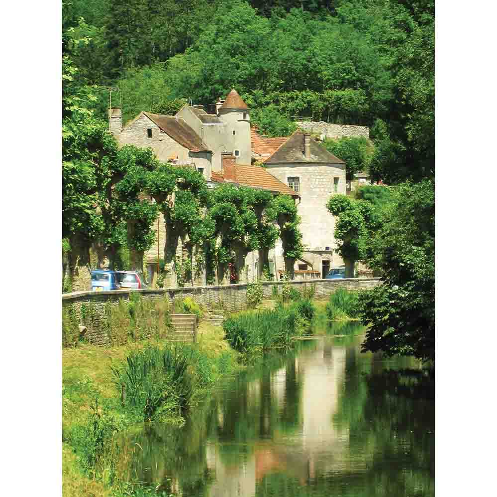 Traditional stone building with a terra cotta roof surrounded by greenery and a river in France wall decal printed | Wallhogs